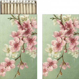Caja de cerillas con diseño floral de flores rosas sobre fondo verde, mostrada abierta y cerrada.