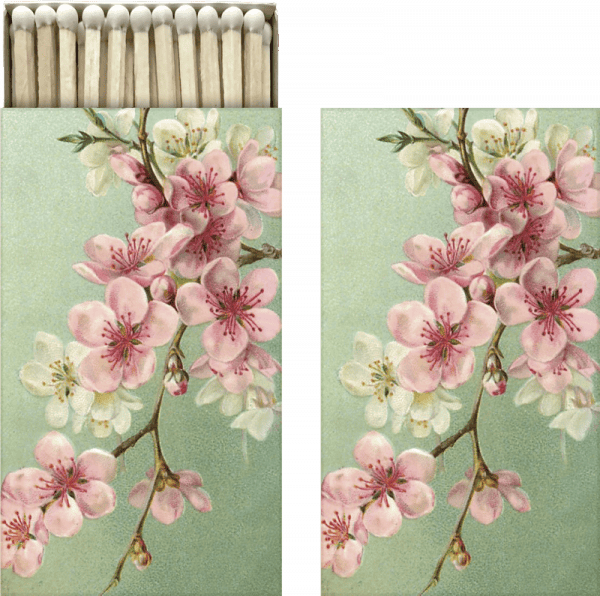 Caja de cerillas con diseño floral de flores rosas sobre fondo verde, mostrada abierta y cerrada.