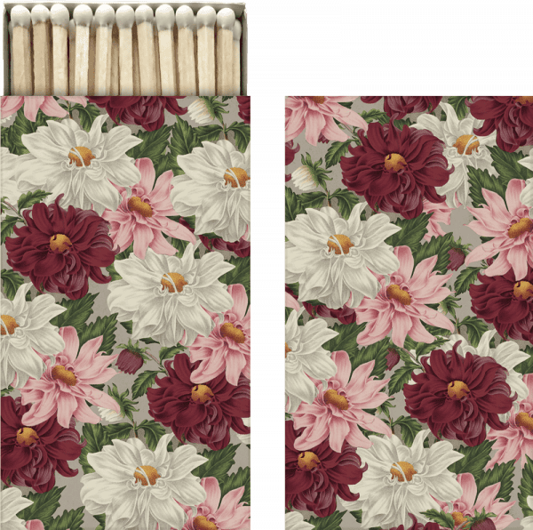 Una caja de cerillas con diseño floral, con flores rojas, blancas y rosas sobre un fondo gris. Las cerillas se ven en la parte superior.