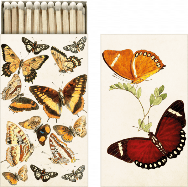Una caja de cerillas con ilustraciones de mariposas, que presentan varias especies en tonos naranja, amarillo y marrón, se muestra junto a una hoja separada con dos mariposas más grandes en una rama.