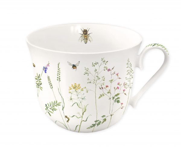Una taza blanca adornada con ilustraciones de flores silvestres y abejas, con un asa curva.
