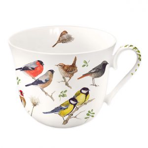 Taza de cerámica blanca con pájaros posados en ramas, entre ellos un camachuelo y un carbonero. El asa tiene un estampado de hojas verdes.