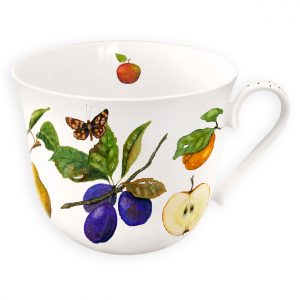 Taza de cerámica blanca con ilustraciones de frutas y mariposas, entre ellas manzanas, ciruelas y una naranja.