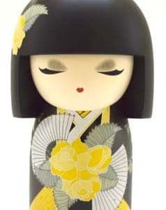 Una muñeca Kokeshi con cabello negro, representada con un atuendo tradicional adornado con patrones florales amarillos y grises.