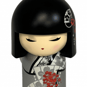 Un pequeño llavero de muñeca kokeshi con cabello negro, vistiendo un kimono gris decorado con flores rojas y negras.