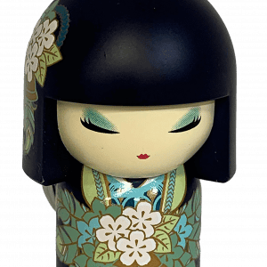 Un pequeño llavero con figura de una muñeca con cabello negro, ojos cerrados y patrones florales en su ropa, sosteniendo un ramo de flores blancas.