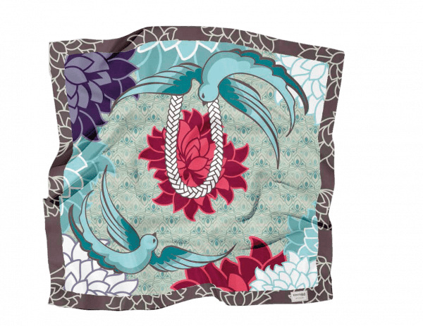 Pañuelo de seda con pájaros azules, flores rojas y violetas y diseño de cuerda sobre fondo verde azulado con patrones geométricos.