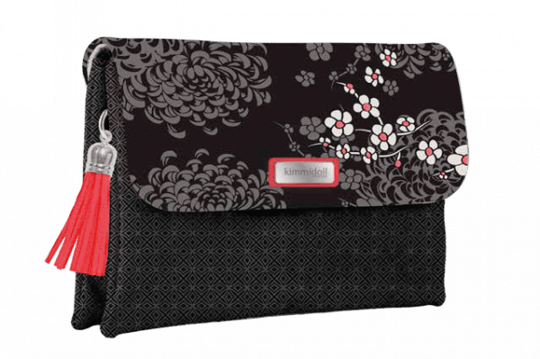 Un bolso de mano negro con estampado floral y detalles en rojo, que presenta una borla roja en el lateral.