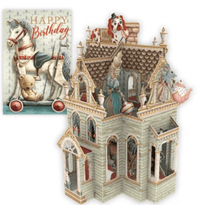 Tarjeta de cumpleaños vintage con un caballo balancín y un osito de peluche junto a una detallada casa de muñecas victoriana en miniatura con figuritas de animales y una mujer en su interior.