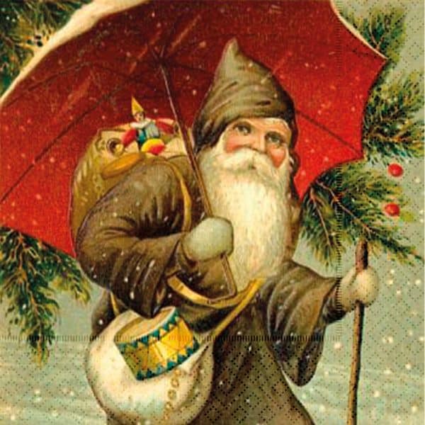 Un hombre de barba blanca y abrigo oscuro con capucha sostiene un paraguas rojo y un bastón, con un saco de juguetes, de pie entre pinos nevados, en la vendimia de servilleta navidad.