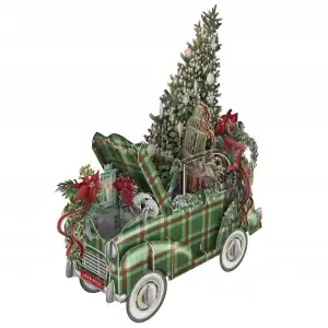 Un coche de juguete verde a cuadros con el capó y el maletero abiertos, decorado con adornos navideños, regalos, un árbol de Navidad y vegetación festiva.