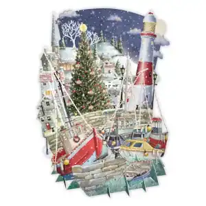 Escena de un puerto nevado con barcos atracados cerca de un muro de piedra, un árbol de Navidad decorado, el faro y edificios del pueblo al fondo.